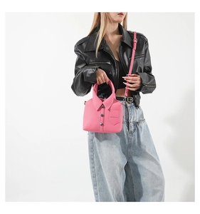 Dettaglio di una borsa rosa a forma di camicia con colletto e bottoni a tracolla
