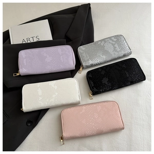 Detailed flat lay of long faux snake texture wallets in five trendy colors and gold zippers