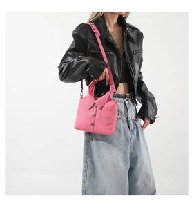 Dettaglio borsa a tracolla rosa acceso stile camicia con bottoni decorativi e cinturino
