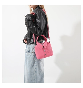 Dettaglio della borsa rosa a forma di camicia con bottoni e finitura in ecopelle grana