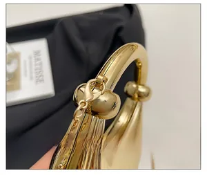 Macro shot of premium polished gold metal hardware and elegant chain on an evening bag