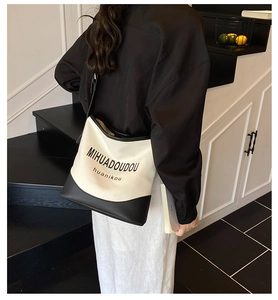 Détail du sac cabas en toile contrastée avec anses en cuir noir et design imprimé