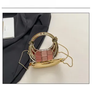 Capacity display of golden hard-shell metal handbag showing interior with makeup palette