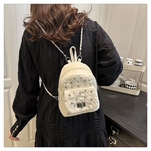 Mini cream quilted backpack with diamond stitching and chain straps worn by model