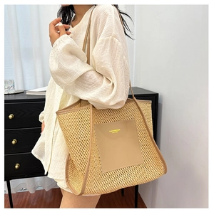 Close-up of beige woven tote bag with brown leather trim and fashion brand patch