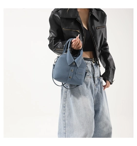Dettaglio di una borsa a mano blu in pelle a forma di camicia con colletto e bottoni