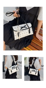 Detail of white PU leather bag featuring black bow print and satin ribbon ornament