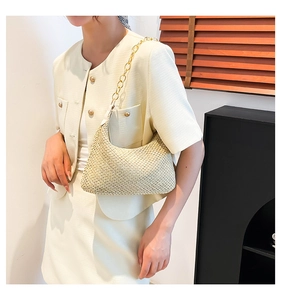 Close-up of woven hobo bag with gold chain strap worn over a beige knit outfit