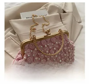 Detail of pink floral evening clutch with pearls, gold frame, and metallic ring handle