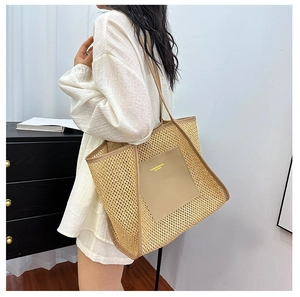 Detail of woven straw tote bag featuring beige leather trim and brand logo patch
