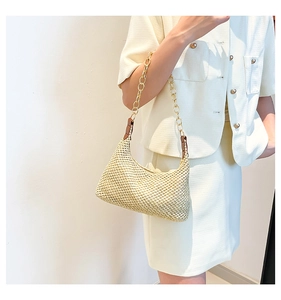 Detail of beige straw shoulder bag with acrylic chain strap and woven texture finish