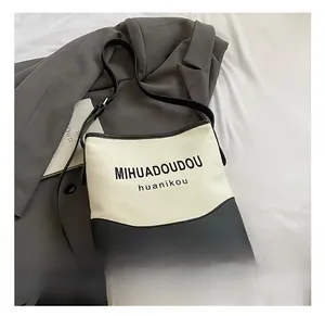 Détail du sac seau en toile avec base en cuir et marquage lettrage élégant