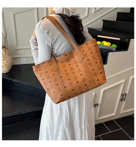 Detail of a brown tote bag featuring vintage bear patterns and slim shoulder straps