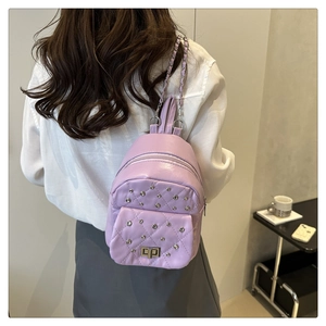 Detail eines hellvioletten Mini-Rucksacks mit Steppmuster, Strass und Kettenriemen