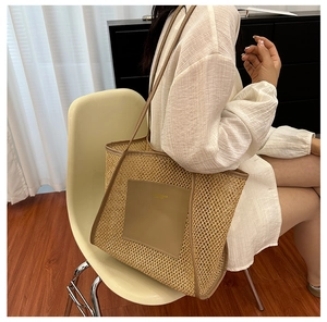 Close-up of beige woven tote bag with brown leather trim and front pocket detail