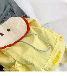 Detailed top view of a yellow crinkled fabric backpack with a unique apple-shaped lid