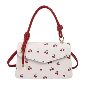 White faux leather crossbody bag with red cherry prints and knotted top handles