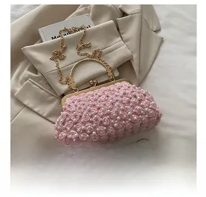 Macro detail showing pink lace 3D floral petals and white pearls on the clutch bag