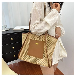 Close-up detail of the woven texture and brown leather pocket on the large tote bag