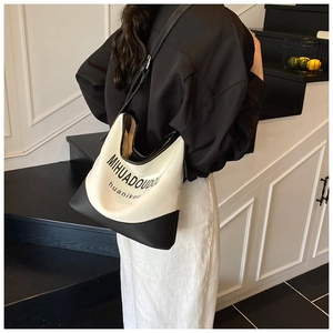 Détail porté épaule d'un sac cabas bicolore en toile avec bandoulière contrastée