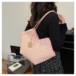 Détail du sac cabas rose avec logo doré rond et texture en similicuir à motif monogramme