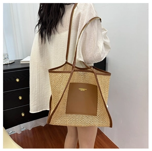 Detail of beige woven straw tote with brown leather trim and shoulder strap on model