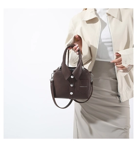 Detalle de bolso estilo blazer con diseño de solapa, botones plateados y bolsillo