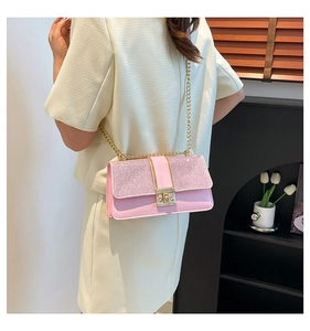 Pink patchwork chain bag with gold buckle shown on a model in a minimalist setting