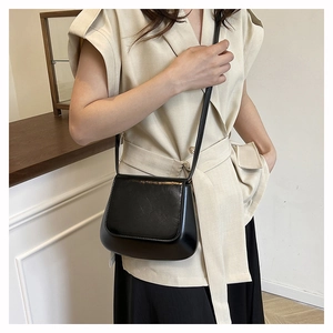 Chic black faux leather saddle bag worn by a model to show everyday styling and size
