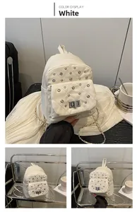 Detail eines weißen Stepp-Minirucksacks mit Strassnieten und silbernem Drehverschluss