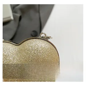 Dettaglio ravvicinato della borsa da sera a cuore color champagne con texture glitterata