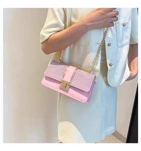 Close-up of pink chain bag with glitter flap and gold metal square lock detail