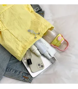 Detail of yellow nylon drawstring bag showing spacious interior with personal essentials