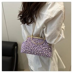 Detail of purple lace floral evening bag with white pearl accents and gold metal chain