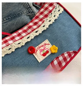 Detailed close-up of blue denim pet bib with lace edges and cherry garden embroidery