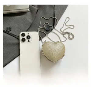 Dettaglio della mini borsa a cuore con finitura glitter dorata e tracolla a catena