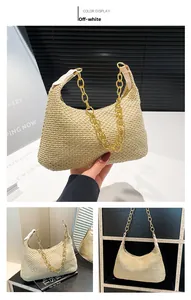 Detail of off-white woven straw tote bag with gold chunky chain strap and leather handle