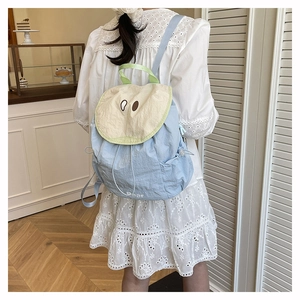Detail of light blue nylon drawstring backpack with bear design in a cafe setting