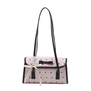 Pink pleated shoulder bag with black contrast trim and bow accents on white background