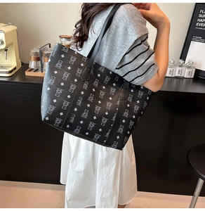 Black tote bag with cartoon bear and geometric patterns in a lifestyle setting