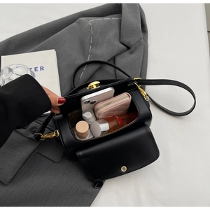 Detail of black cylindrical crossbody bag showing large capacity for phone and cosmetics