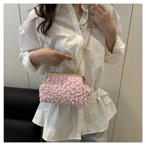 Detail of purple beaded evening clutch with 3D floral accents and pearl embellishments