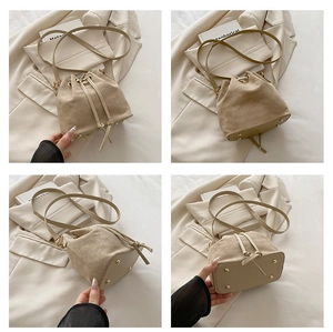 Macro view of beige suede bucket bag showing drawstring detail and metal bottom studs