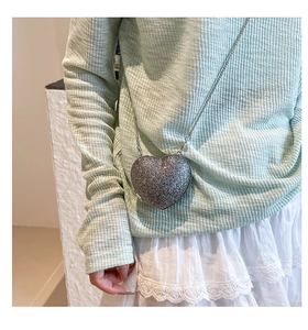 Dettaglio della mini borsa argento a cuore con glitter e catena metallica sottile