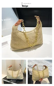 Detail of woven crescent hobo bag in beige straw and brown leather with gold chain strap