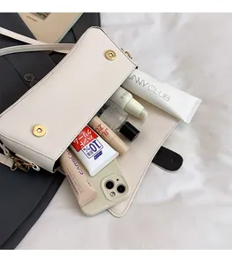 Interior view of off-white leather bag showing storage space for phone and makeup items