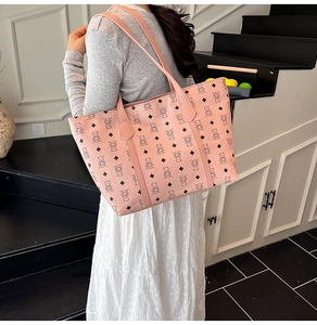 Detail of light pink tote bag featuring black cartoon bear prints and dual shoulder straps