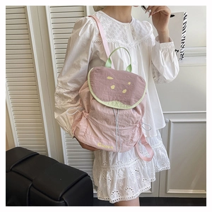 Detail of pink guava-themed backpack with drawstring and textured fabric