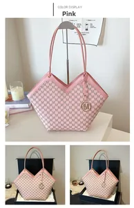 Pink tote bag detail with textured M pattern and decorative metal charm accessory