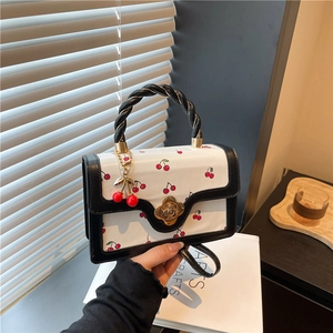 White cherry print crossbody square bag with woven handle and gold floral clasp